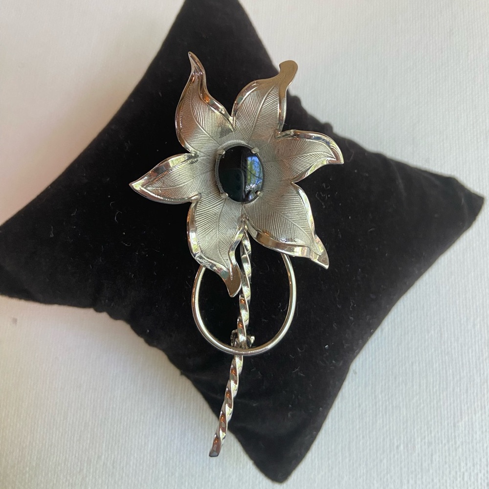 Flower brooch pin with center black glass cabochon in textured silvertone metal